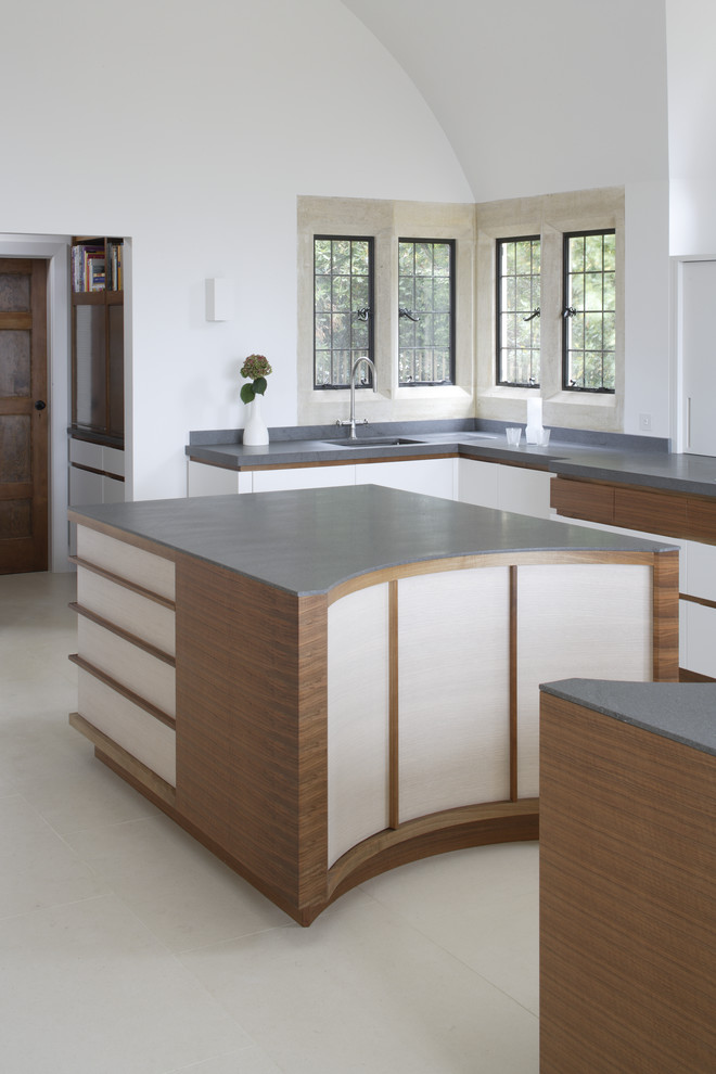 Large modern l-shaped open plan kitchen in Surrey with medium wood cabinets, granite worktops and multiple islands.