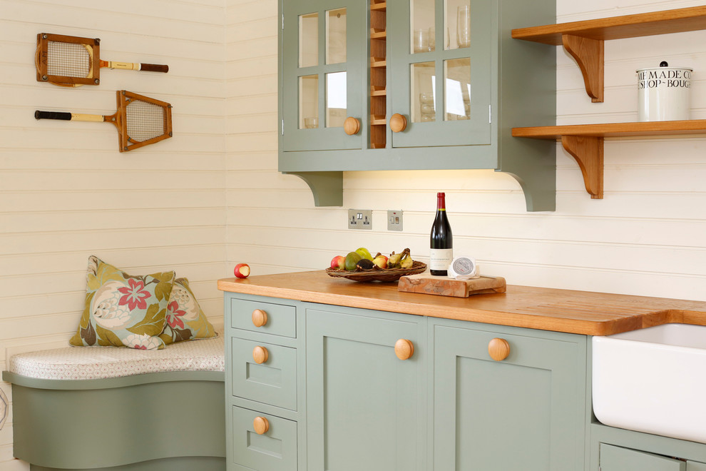 Idée de décoration pour une cuisine tradition avec des portes de placard bleues et un plan de travail en bois.