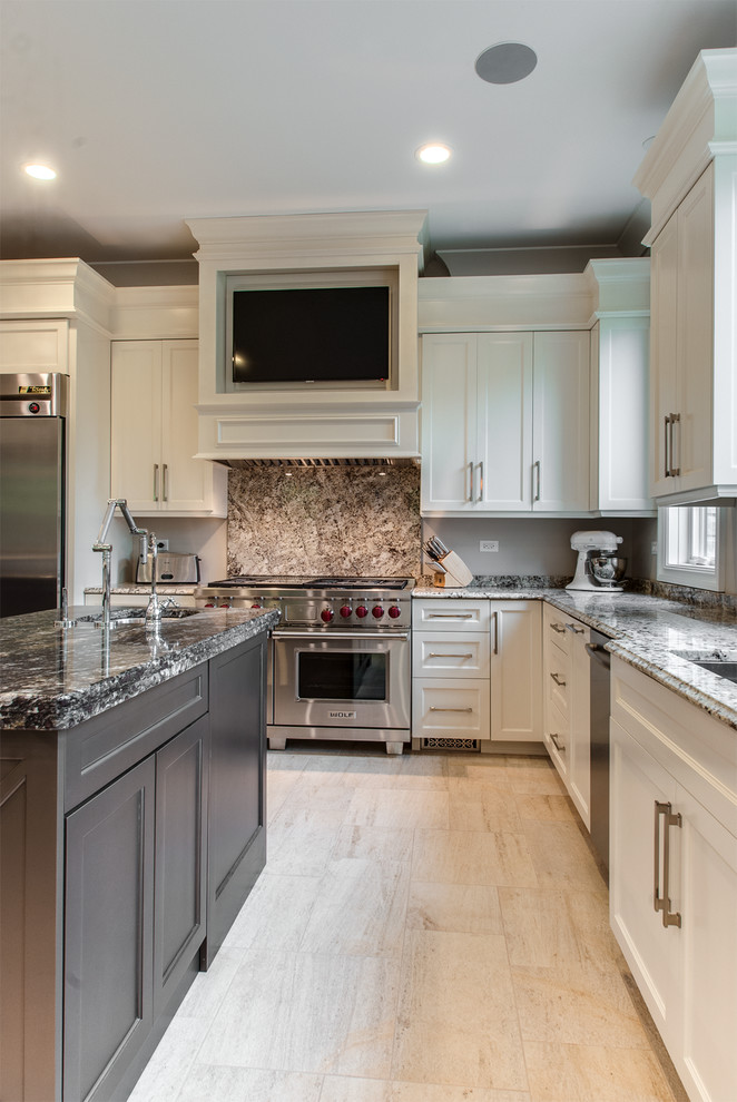 Klassisk inredning av ett kök, med en undermonterad diskho, skåp i shakerstil, vita skåp, rostfria vitvaror och en köksö