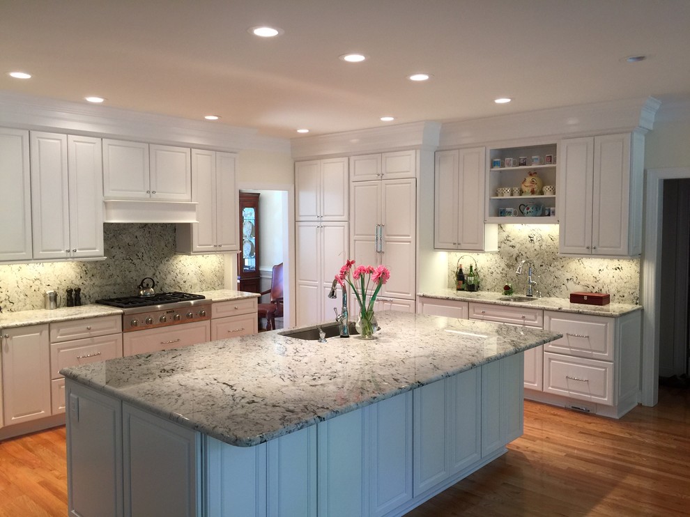 Large elegant l-shaped light wood floor eat-in kitchen photo in Raleigh with an island, raised-panel cabinets, white cabinets, granite countertops, multicolored backsplash, stone slab backsplash, paneled appliances and a single-bowl sink
