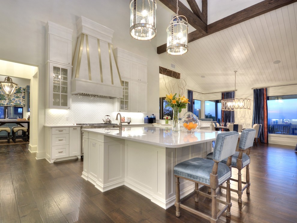 Design ideas for a traditional open plan kitchen in Austin with shaker cabinets, white cabinets, white splashback, stainless steel appliances, dark hardwood flooring and an island.