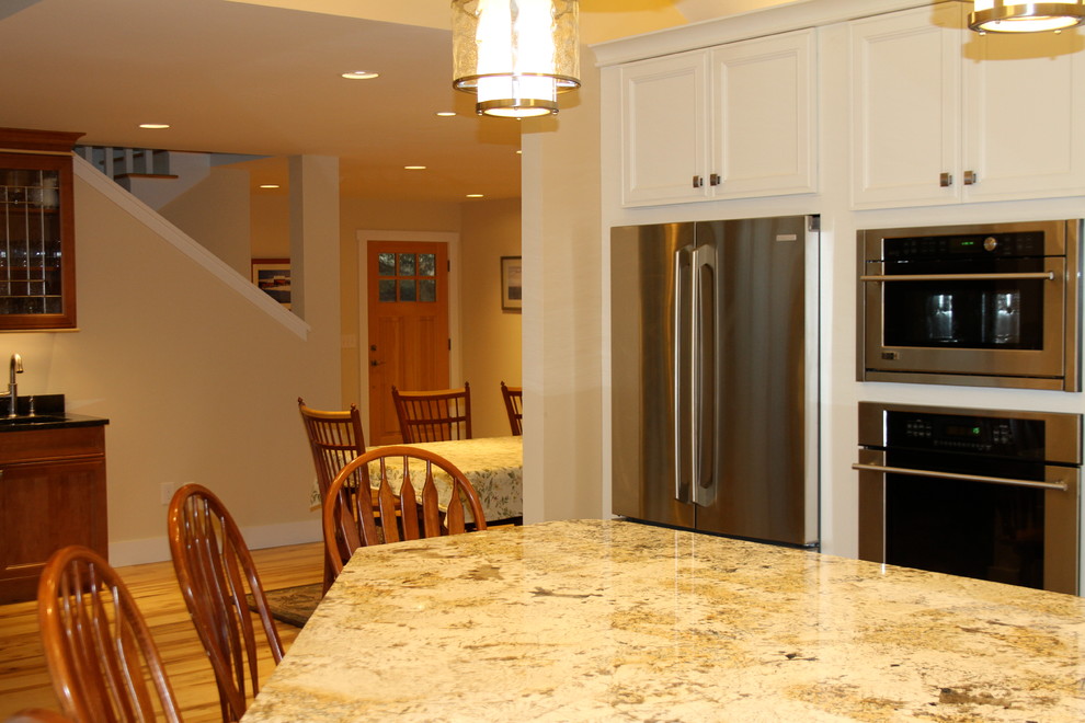 Esempio di una grande cucina chic con ante lisce, ante bianche, top in granito e elettrodomestici in acciaio inossidabile