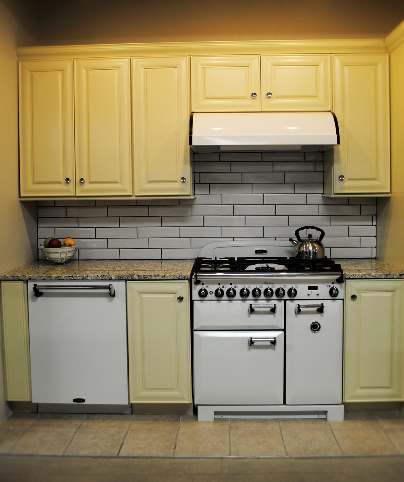 Esempio di una cucina parallela chic di medie dimensioni con ante gialle, top in granito, paraspruzzi bianco e paraspruzzi con piastrelle in ceramica