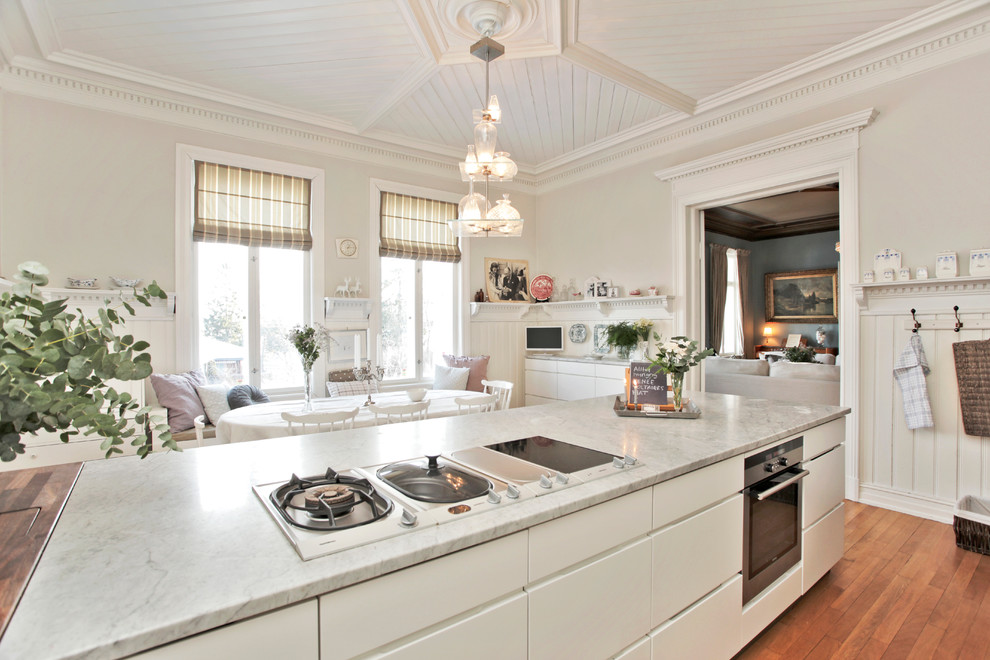 На фото: кухня в стиле неоклассика (современная классика) с обеденным столом, плоскими фасадами, белыми фасадами и шторами на окнах