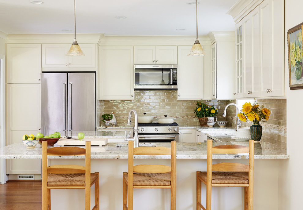 Inspiration for a timeless u-shaped medium tone wood floor kitchen remodel in DC Metro with a farmhouse sink, shaker cabinets, beige cabinets, beige backsplash, subway tile backsplash, stainless steel appliances and a peninsula