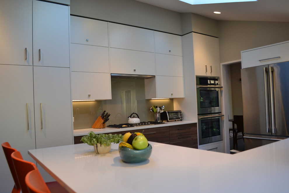 Eat-in kitchen - mid-sized contemporary u-shaped dark wood floor and brown floor eat-in kitchen idea in Other with an undermount sink, flat-panel cabinets, white cabinets, solid surface countertops, white backsplash, stainless steel appliances, a peninsula and glass sheet backsplash