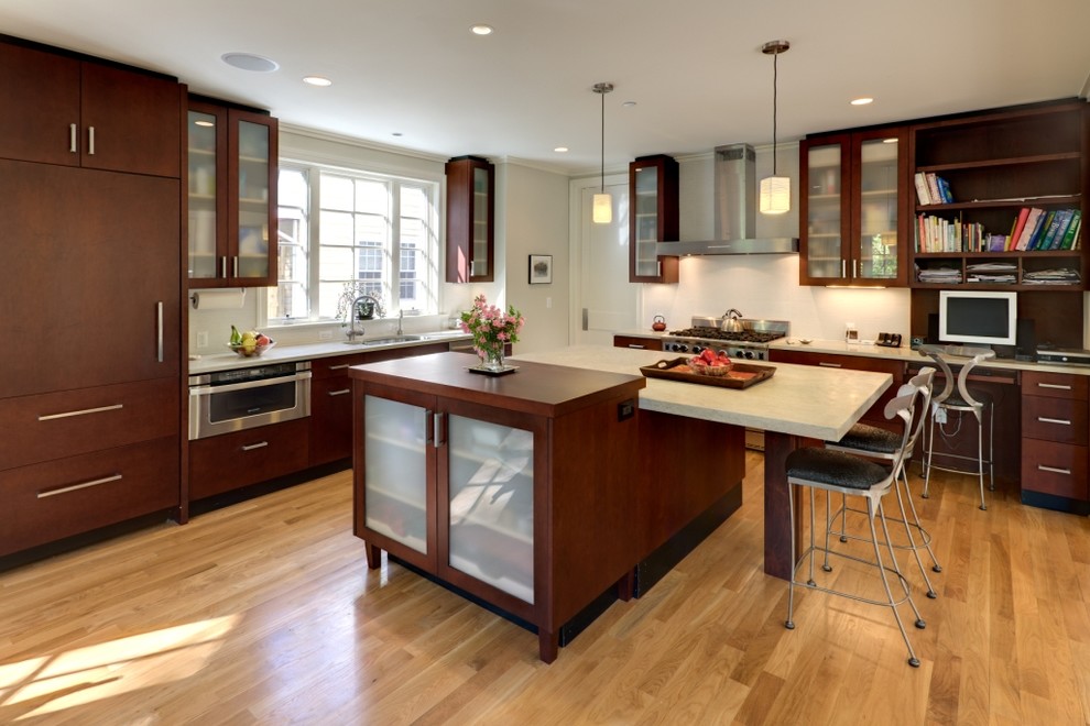 Inspiration for a large contemporary l-shaped light wood floor and beige floor eat-in kitchen remodel in DC Metro with an undermount sink, flat-panel cabinets, dark wood cabinets, wood countertops, white backsplash, stainless steel appliances, an island and cement tile backsplash