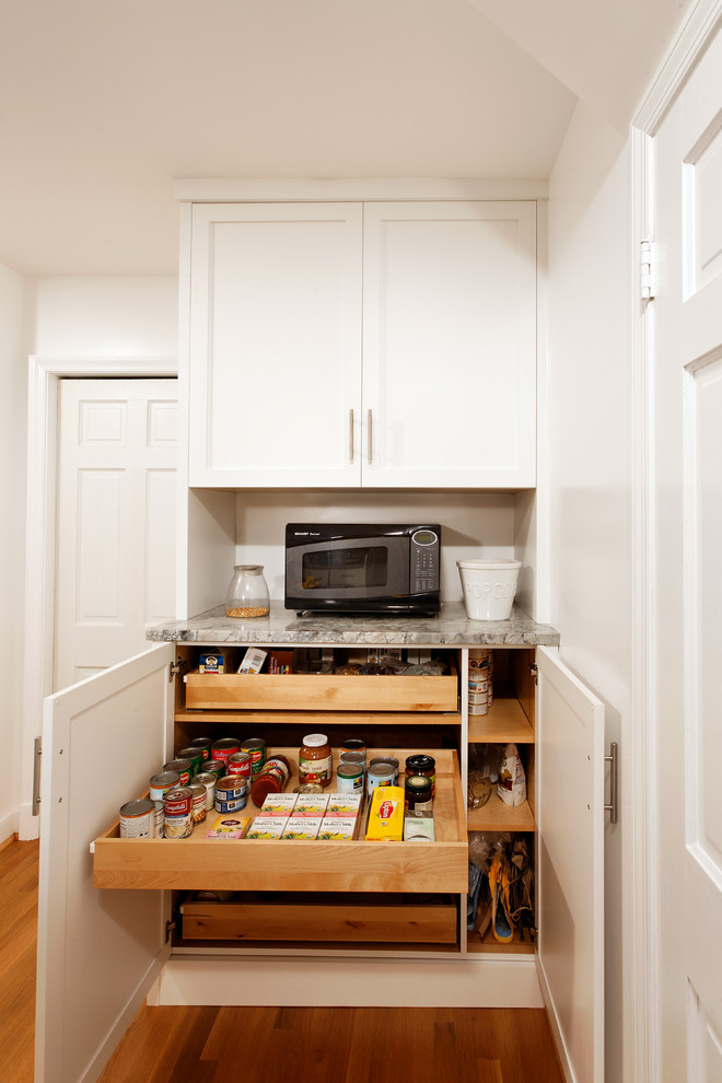 Exempel på ett litet klassiskt kök, med en undermonterad diskho, vita skåp, granitbänkskiva, vitt stänkskydd, stänkskydd i tunnelbanekakel, rostfria vitvaror, mellanmörkt trägolv, en halv köksö och skåp i shakerstil