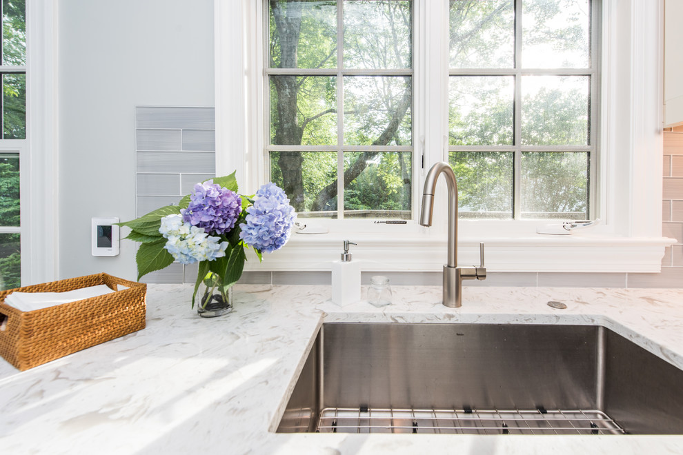 Mid-sized trendy galley slate floor and multicolored floor eat-in kitchen photo in DC Metro with an undermount sink, recessed-panel cabinets, white cabinets, quartz countertops, gray backsplash, subway tile backsplash, stainless steel appliances, a peninsula and white countertops