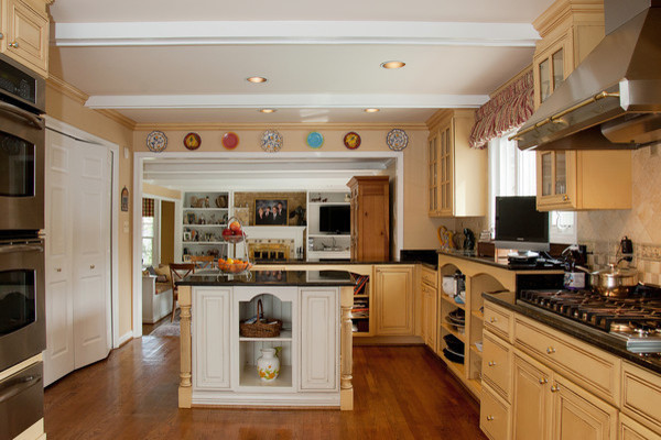 Ejemplo de cocina de estilo de casa de campo grande con despensa, armarios tipo vitrina, puertas de armario amarillas, encimera de granito y una isla