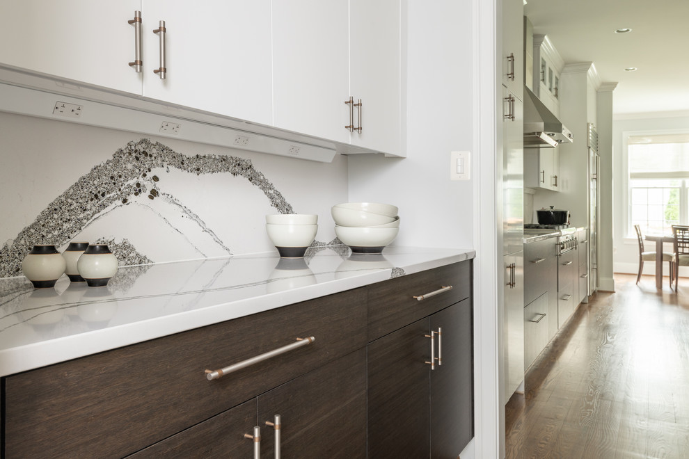This is an example of a large contemporary open plan kitchen in DC Metro with flat-panel cabinets, white cabinets, stainless steel appliances, medium hardwood flooring, multiple islands and white worktops.