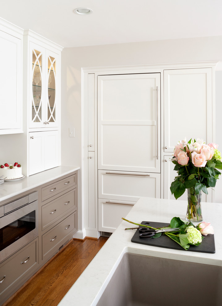 Foto de cocina clásica renovada de tamaño medio con puertas de armario blancas, salpicadero blanco, electrodomésticos de acero inoxidable y una isla