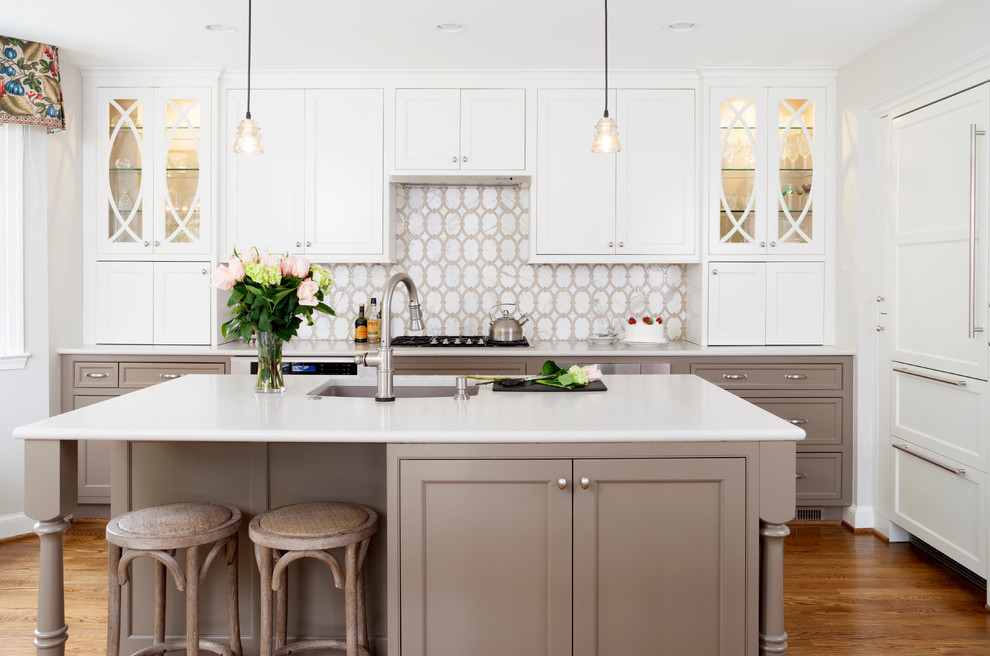 Example of a mid-sized transitional l-shaped medium tone wood floor eat-in kitchen design in DC Metro with white cabinets, white backsplash, stainless steel appliances, an island, an undermount sink and recessed-panel cabinets