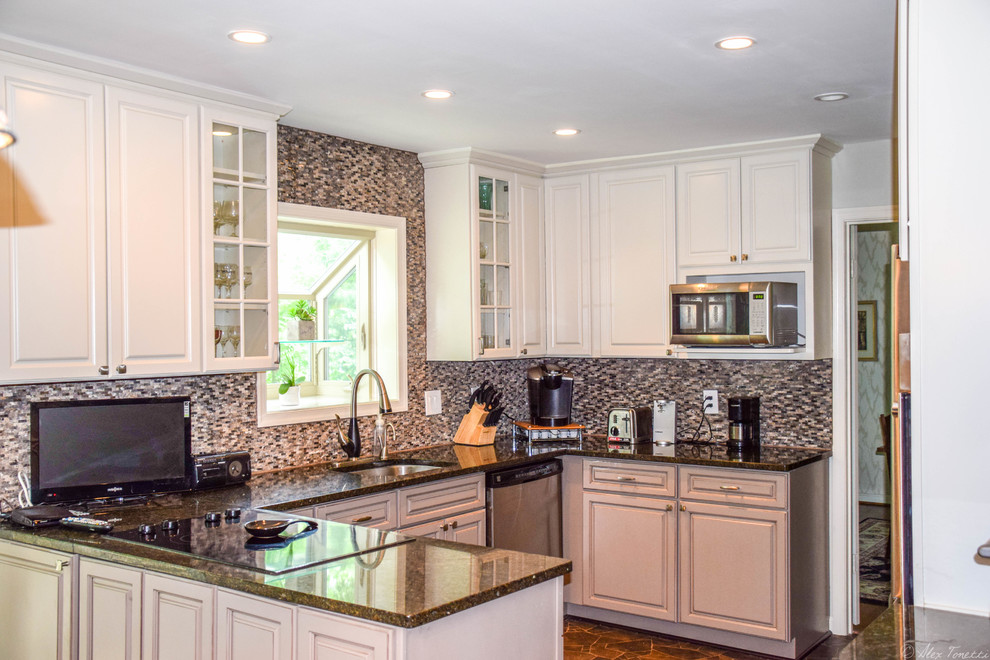 Bild på ett mellanstort eklektiskt kök, med granitbänkskiva, rostfria vitvaror, en nedsänkt diskho, luckor med upphöjd panel, klinkergolv i keramik, en halv köksö, gula skåp, flerfärgad stänkskydd, stänkskydd i mosaik och brunt golv