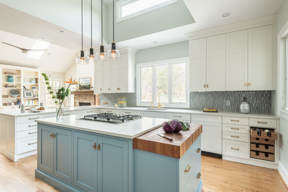 Example of a large transitional l-shaped kitchen pantry design in DC Metro with shaker cabinets, blue cabinets, wood countertops, blue backsplash, ceramic backsplash, paneled appliances and an island