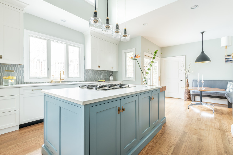 This is an example of a large classic l-shaped kitchen pantry in DC Metro with shaker cabinets, blue cabinets, wood worktops, blue splashback, ceramic splashback, integrated appliances and an island.