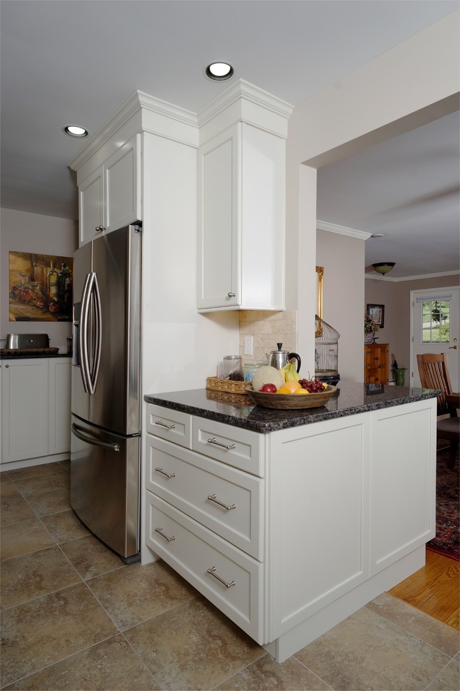 Eat-in kitchen - mid-sized transitional ceramic tile and beige floor eat-in kitchen idea in Philadelphia with an undermount sink, recessed-panel cabinets, white cabinets, granite countertops, beige backsplash, porcelain backsplash, stainless steel appliances, an island and black countertops