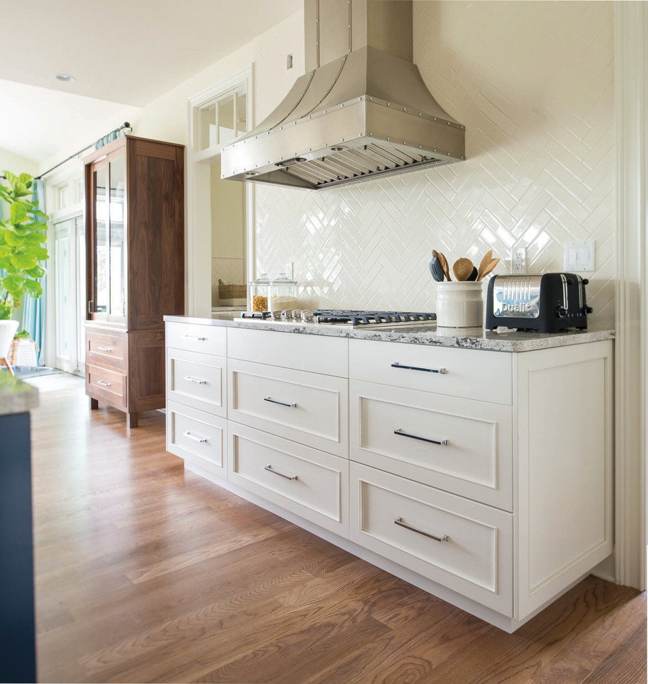 Foto di un cucina con isola centrale classico con ante in stile shaker, paraspruzzi bianco, elettrodomestici in acciaio inossidabile e ante bianche