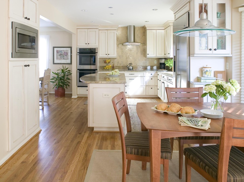Inspiration for a mid-sized transitional l-shaped light wood floor and beige floor eat-in kitchen remodel in DC Metro with an undermount sink, recessed-panel cabinets, white cabinets, beige backsplash, stainless steel appliances and an island