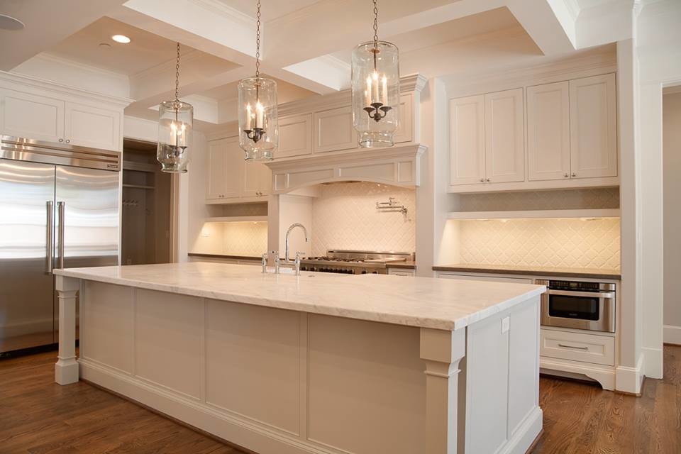 Inspiration for a large traditional kitchen/diner in Phoenix with recessed-panel cabinets, white cabinets, medium hardwood flooring, brown floors, a belfast sink, marble worktops, white splashback, stone tiled splashback, stainless steel appliances and an island.