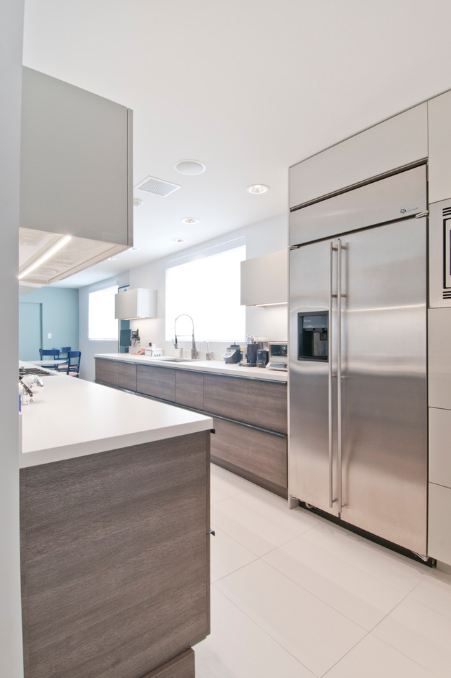 Foto på ett mellanstort funkis kök, med en undermonterad diskho, släta luckor, grå skåp, bänkskiva i kvartsit, rött stänkskydd, rostfria vitvaror, klinkergolv i porslin och turkost golv