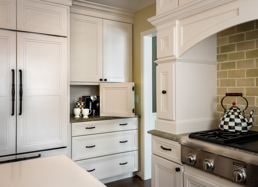 Bild på ett stort vintage vit vitt kök, med en rustik diskho, luckor med upphöjd panel, vita skåp, granitbänkskiva, grönt stänkskydd, stänkskydd i keramik, rostfria vitvaror, mörkt trägolv, en köksö och brunt golv