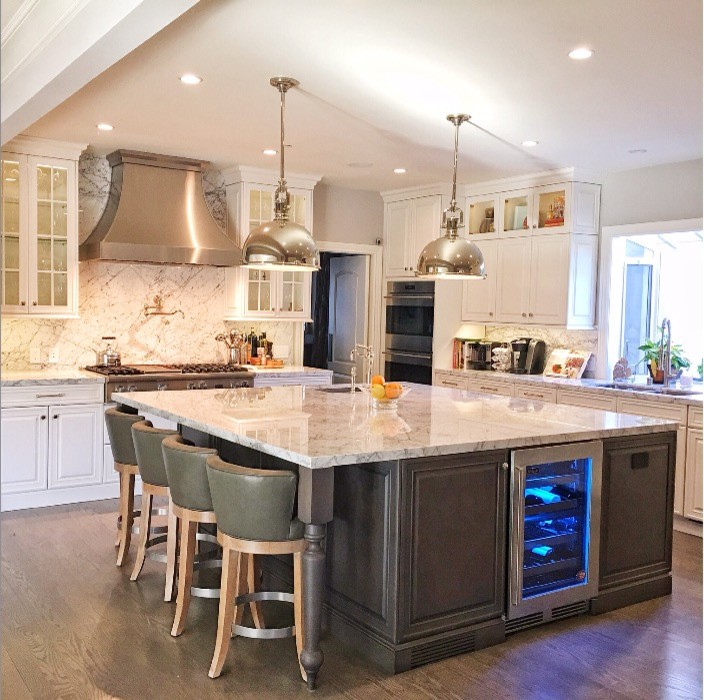 Example of a large classic l-shaped light wood floor and brown floor eat-in kitchen design in Los Angeles with an undermount sink, raised-panel cabinets, white cabinets, granite countertops, gray backsplash, stone slab backsplash, stainless steel appliances, an island and gray countertops
