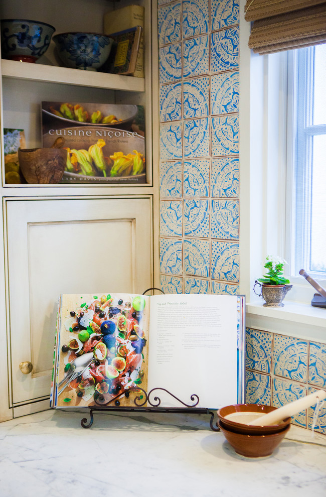 Foto de cocina mediterránea de tamaño medio con armarios con paneles empotrados, puertas de armario beige, encimera de mármol, salpicadero azul, salpicadero de azulejos de cerámica y una isla