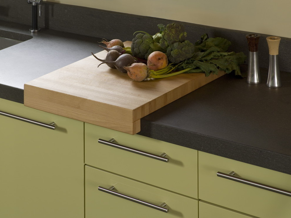 Foto di una cucina minimal di medie dimensioni con lavello sottopiano, nessun'anta, ante verdi, paraspruzzi nero e parquet scuro
