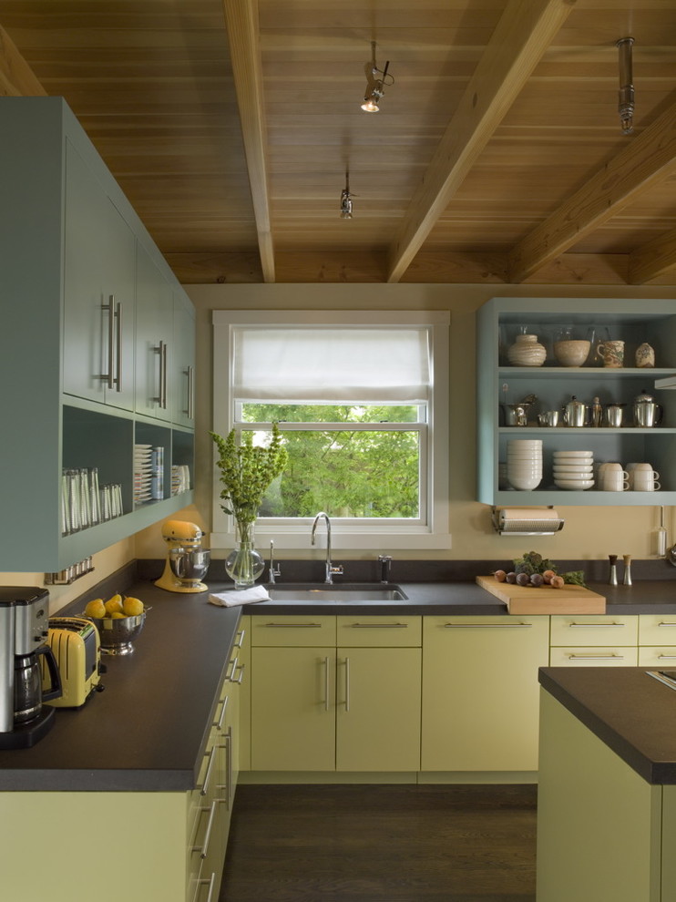 Open concept kitchen - mid-sized contemporary l-shaped dark wood floor open concept kitchen idea in San Francisco with open cabinets, paneled appliances, an island, an undermount sink, green cabinets and black backsplash