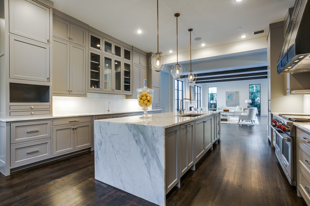 Design ideas for an expansive galley open plan kitchen in Dallas with a submerged sink, recessed-panel cabinets, grey cabinets, marble worktops, white splashback, stainless steel appliances, medium hardwood flooring and an island.