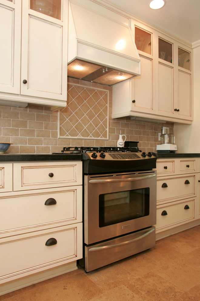 Imagen de cocina comedor tradicional con puertas de armario con efecto envejecido y electrodomésticos de acero inoxidable