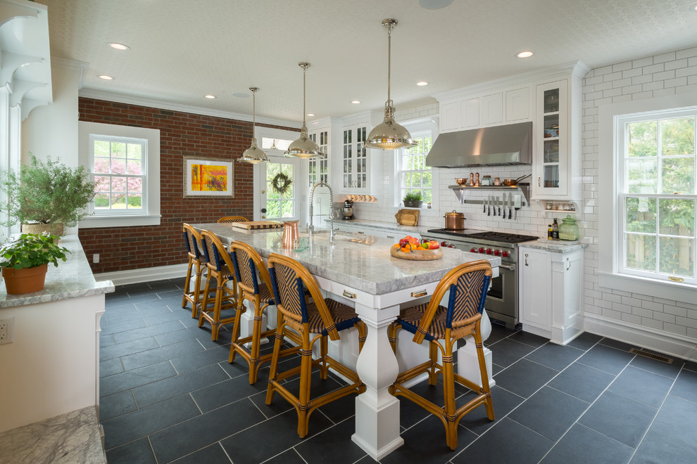 Elegant galley black floor kitchen photo in Columbus with an undermount sink, shaker cabinets, white cabinets, white backsplash, subway tile backsplash, an island and gray countertops