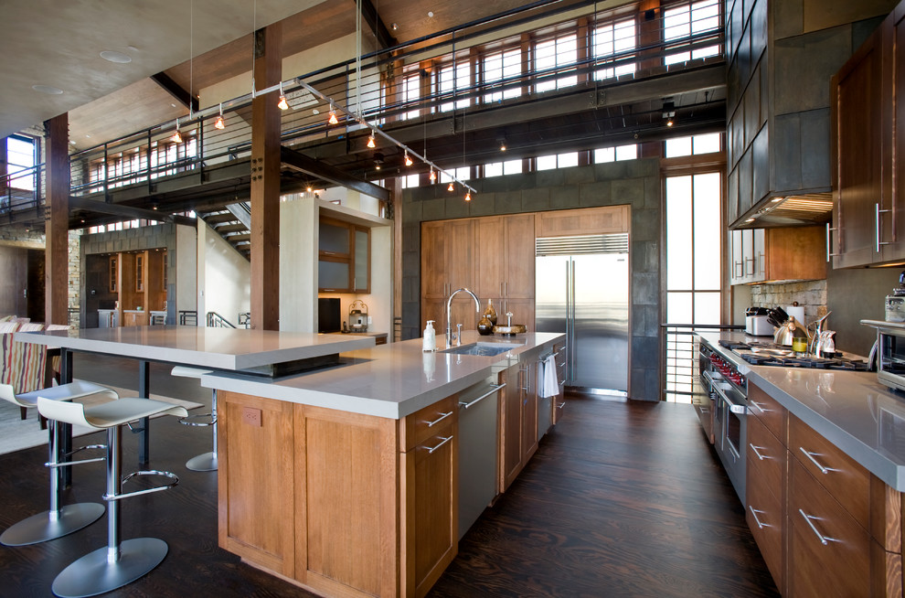 Example of a large trendy galley dark wood floor and brown floor open concept kitchen design in Denver with an undermount sink, recessed-panel cabinets, light wood cabinets, stainless steel appliances, solid surface countertops and an island
