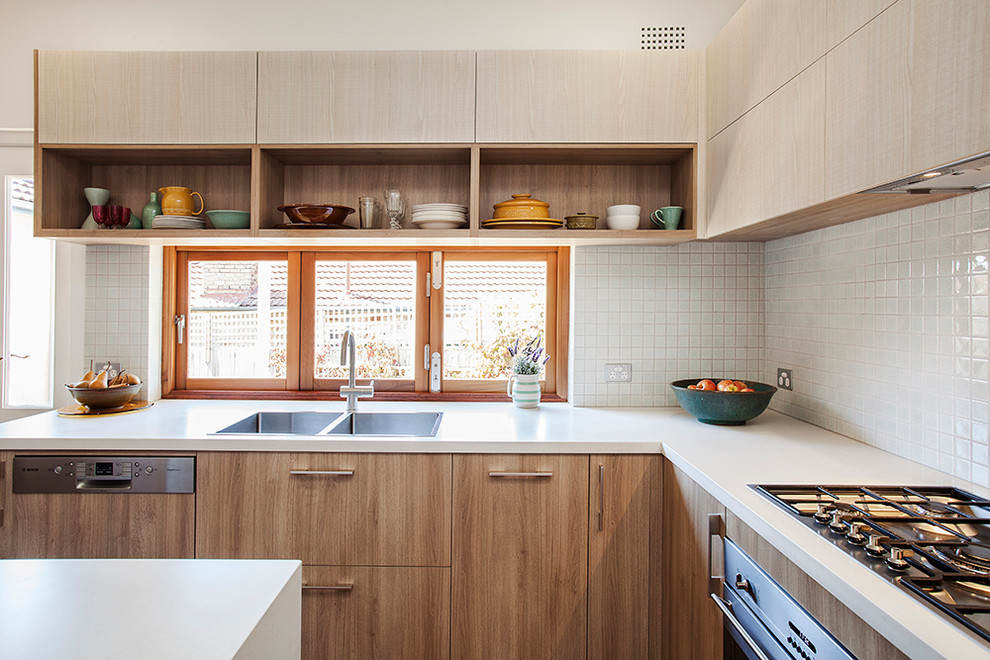 Photo of a mid-sized scandinavian u-shaped eat-in kitchen in Sydney with light wood cabinets, white splashback, mosaic tile splashback, stainless steel appliances and with island.