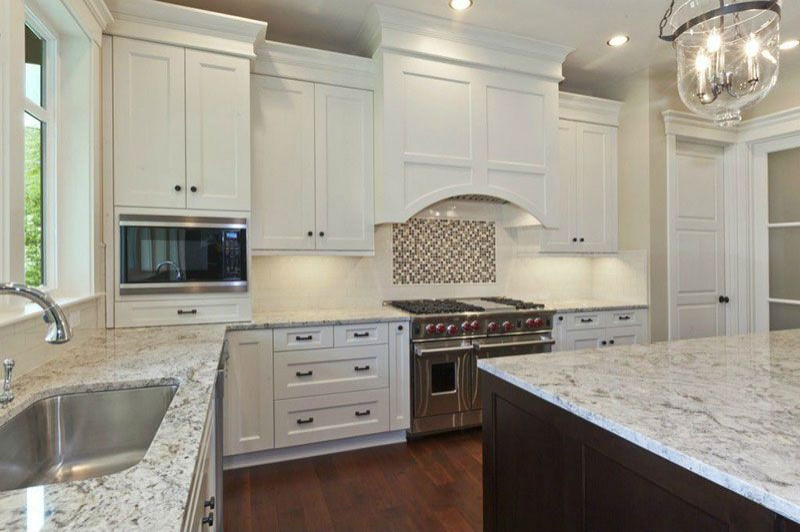 Foto di una cucina abitabile country con ante bianche, top in granito e pavimento bianco