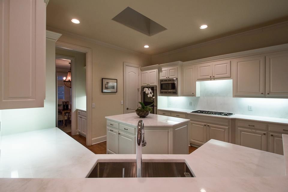 Transitional medium tone wood floor kitchen photo in Dallas with shaker cabinets, white cabinets, marble countertops, white backsplash, marble backsplash and an island