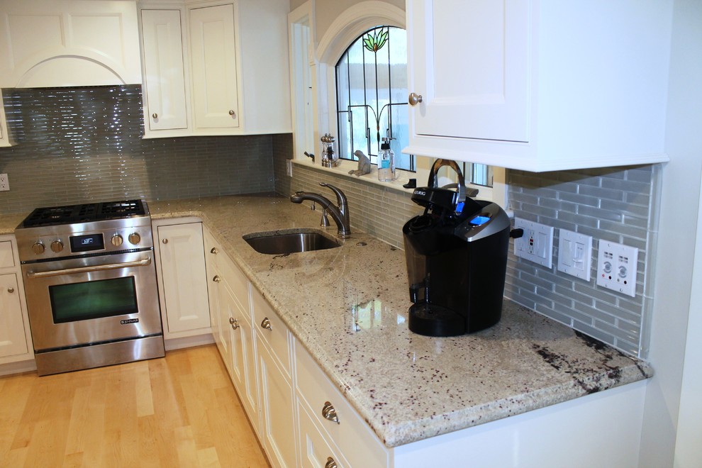 Klassische Wohnküche in U-Form mit Unterbauwaschbecken, weißen Schränken, Granit-Arbeitsplatte, Küchenrückwand in Grau, Rückwand aus Glasfliesen und Küchengeräten aus Edelstahl in Boston