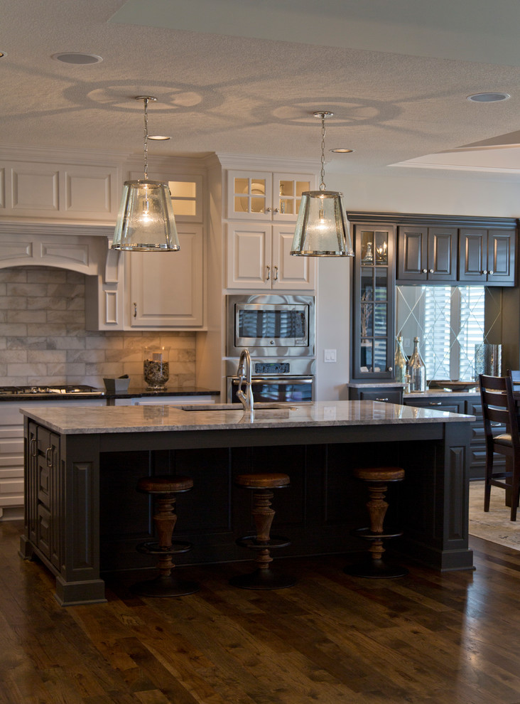 Example of a large minimalist l-shaped open concept kitchen design in Kansas City with louvered cabinets, white cabinets, granite countertops, beige backsplash, ceramic backsplash and an island