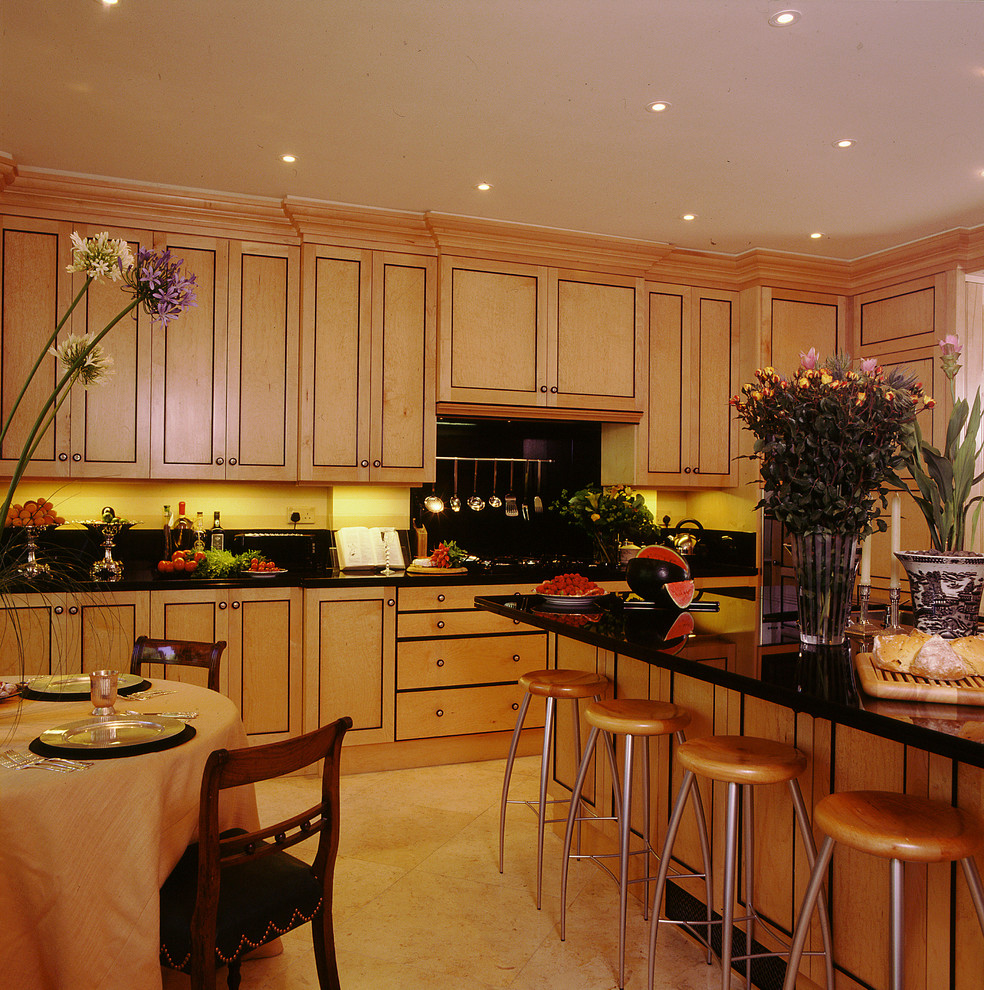 Exempel på ett klassiskt kök och matrum, med skåp i mellenmörkt trä och svart stänkskydd