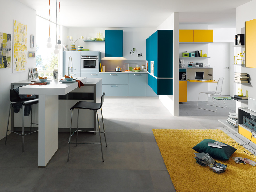 Inspiration for a medium sized modern l-shaped kitchen/diner in Surrey with flat-panel cabinets, blue cabinets, stainless steel appliances and a breakfast bar.