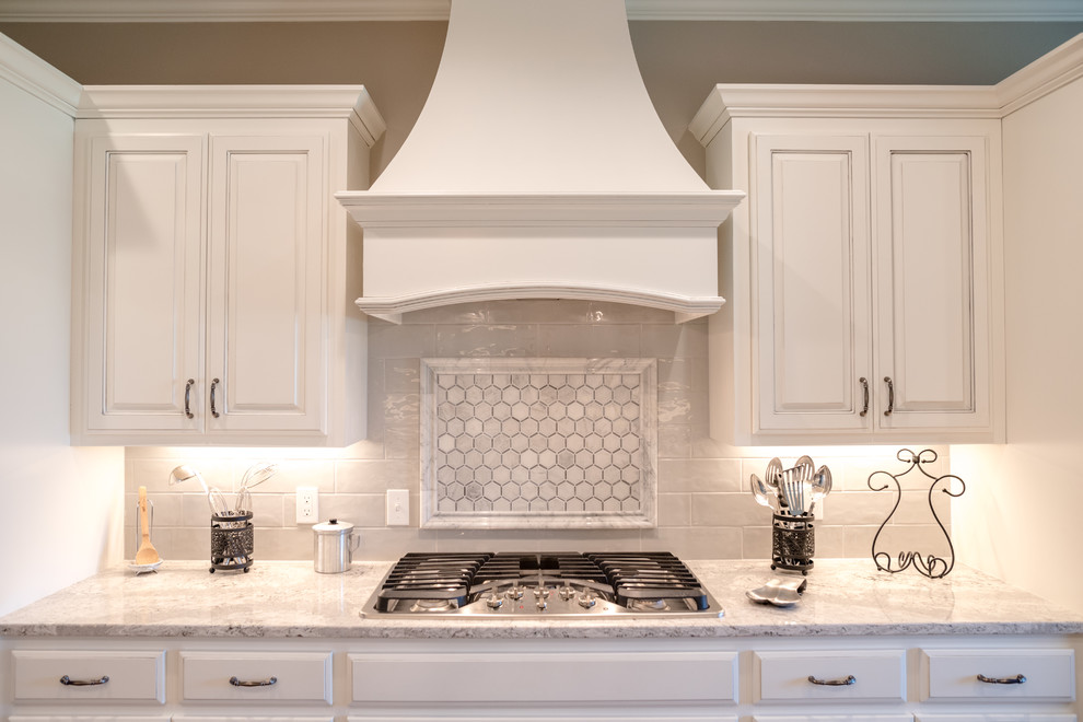 Exempel på ett avskilt, stort klassiskt grå grått u-kök, med en rustik diskho, luckor med upphöjd panel, vita skåp, bänkskiva i kvarts, grått stänkskydd, stänkskydd i marmor, rostfria vitvaror, mellanmörkt trägolv, en köksö och brunt golv