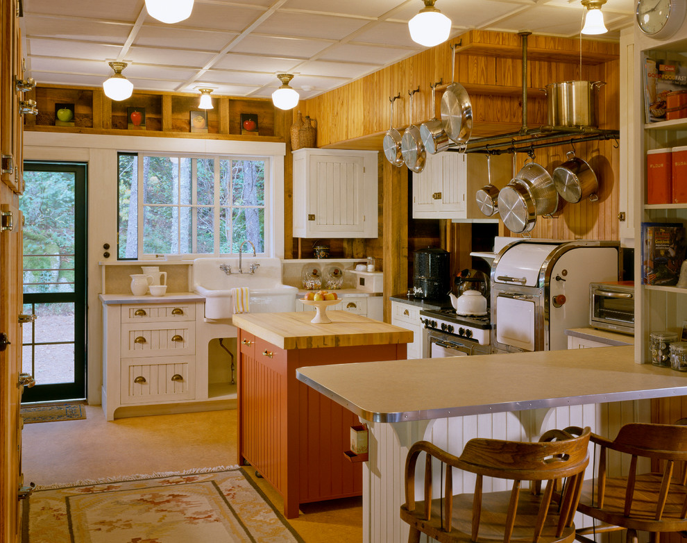 Foto di una grande cucina stile rurale con lavello stile country, ante a filo, ante bianche, top in laminato, paraspruzzi beige, paraspruzzi in legno, elettrodomestici bianchi, pavimento in linoleum e pavimento arancione