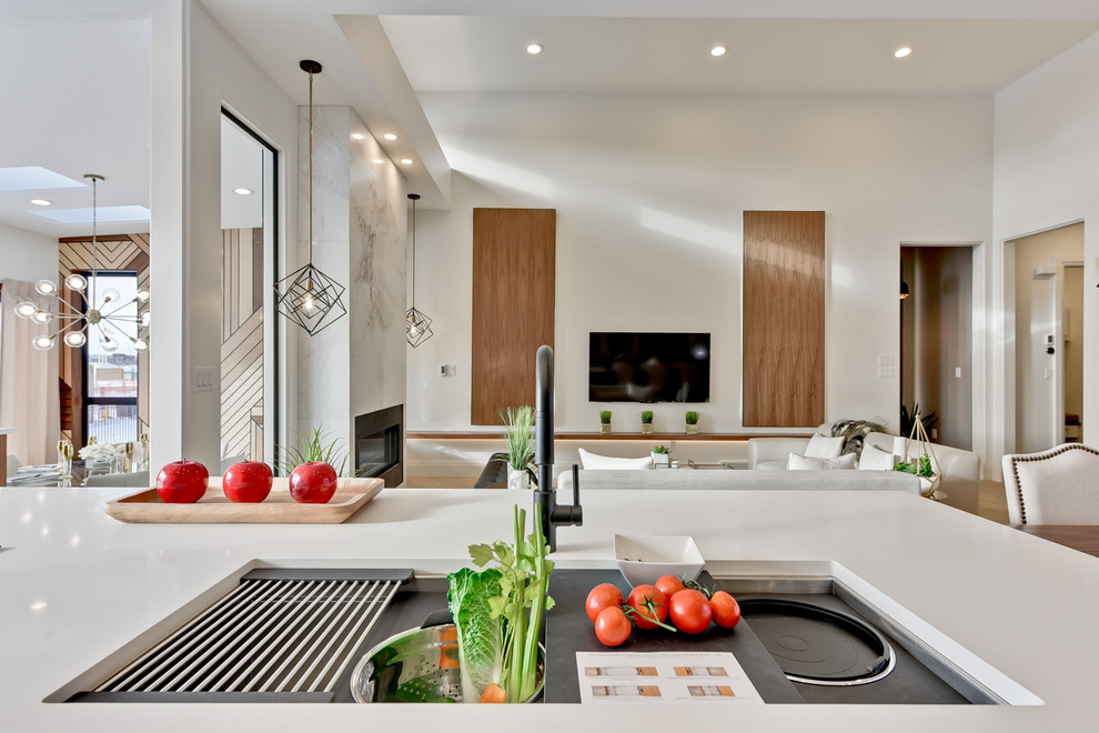 Example of a large trendy light wood floor eat-in kitchen design in Edmonton with an undermount sink, flat-panel cabinets, medium tone wood cabinets, quartz countertops, gray backsplash, marble backsplash, stainless steel appliances and an island