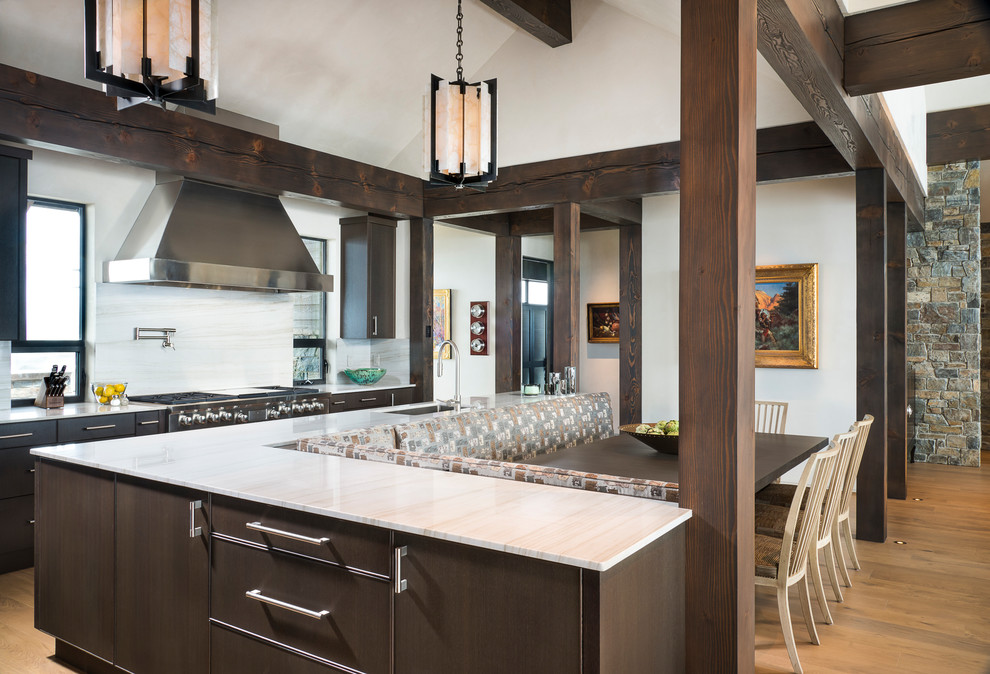 Immagine di una cucina stile rurale con lavello sottopiano, ante in legno bruno, paraspruzzi bianco, elettrodomestici in acciaio inossidabile, parquet chiaro e pavimento beige
