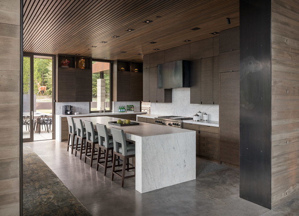 Rustic kitchen in Seattle with flat-panel cabinets, dark wood cabinets, white splashback, stainless steel appliances, concrete flooring, an island, grey floors and white worktops.