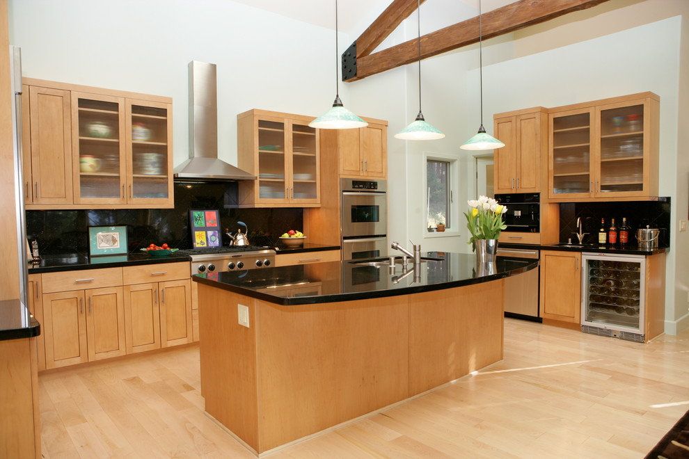 Example of a large minimalist u-shaped light wood floor open concept kitchen design in Other with a double-bowl sink, glass-front cabinets, light wood cabinets, solid surface countertops, black backsplash, ceramic backsplash, stainless steel appliances and an island