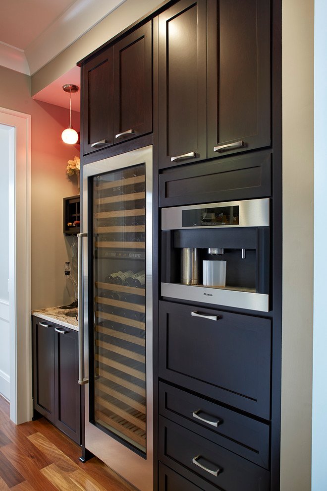 Ispirazione per un cucina con isola centrale chic di medie dimensioni con ante in legno bruno, elettrodomestici in acciaio inossidabile, ante con riquadro incassato e top in granito