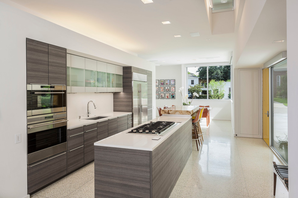 Example of a minimalist galley eat-in kitchen design in Houston with an undermount sink, flat-panel cabinets and stainless steel appliances