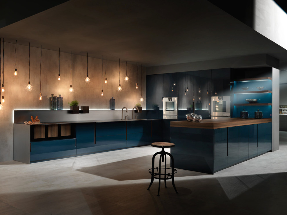 Foto di una grande cucina minimal con lavello a doppia vasca, ante blu, top in legno, elettrodomestici in acciaio inossidabile e pavimento in cemento